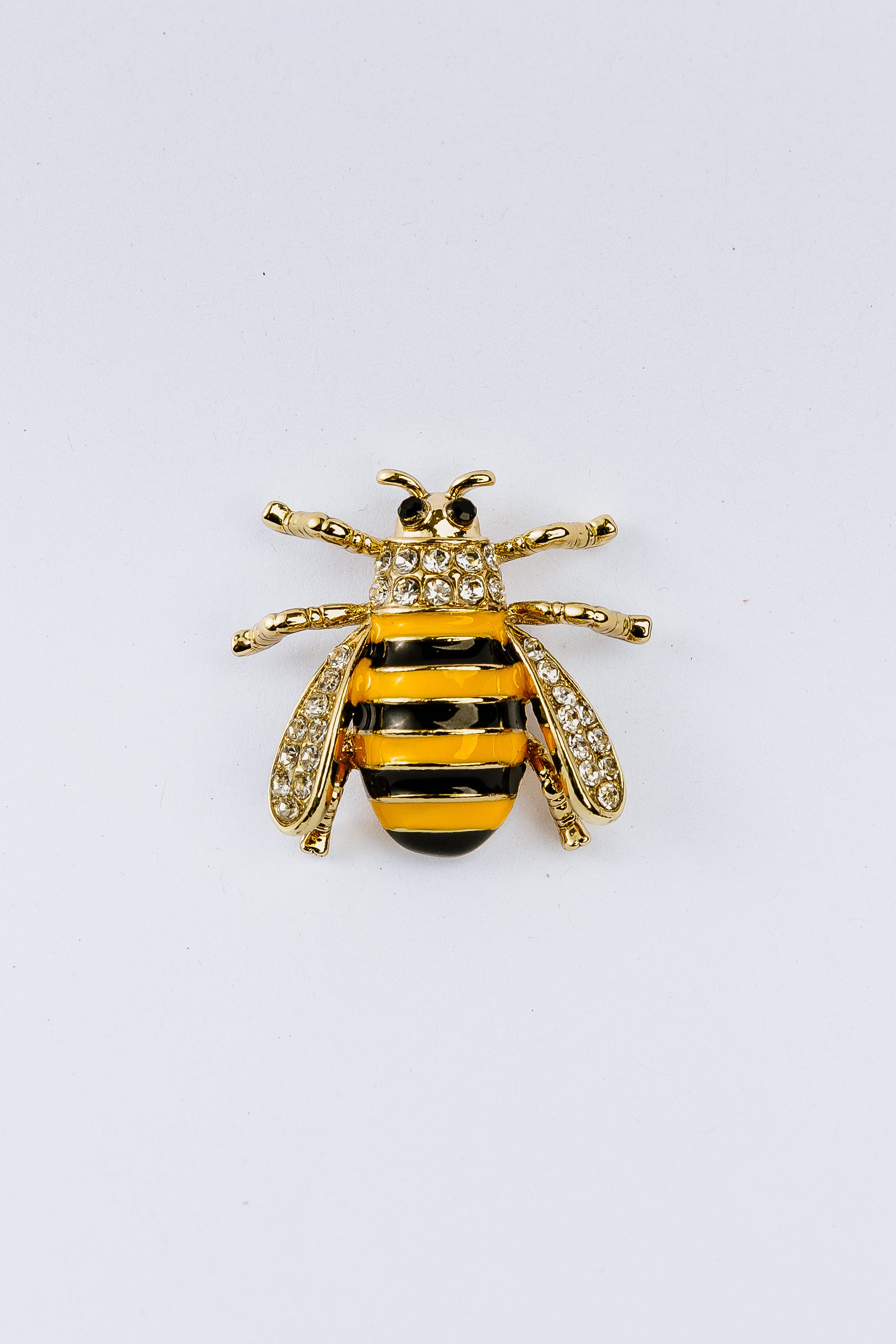 Bee-shaped charm with gold and black stripes on a white background
