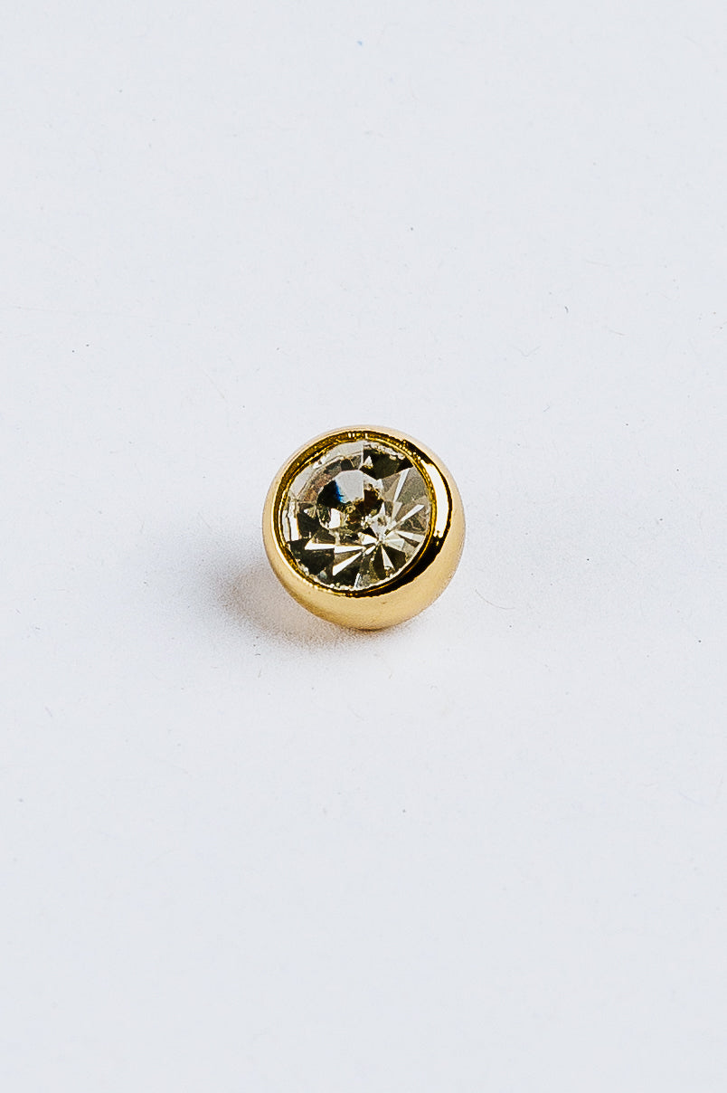 Diamond gemstone in gold alloy on a white background