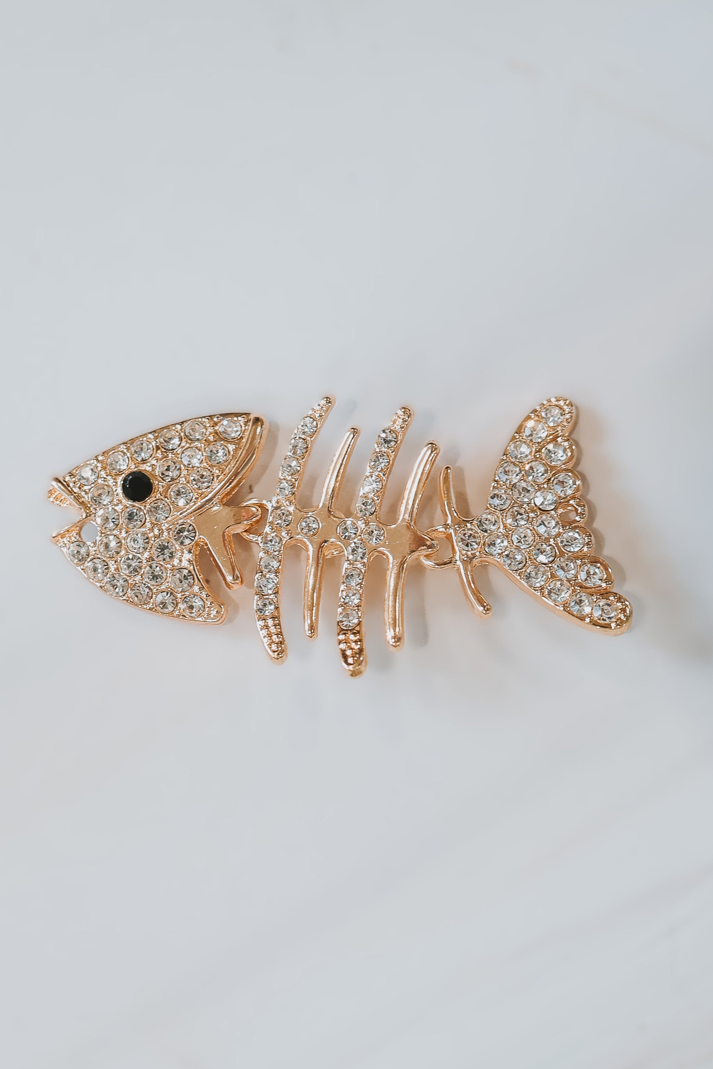 A gold fishbone with gemstones