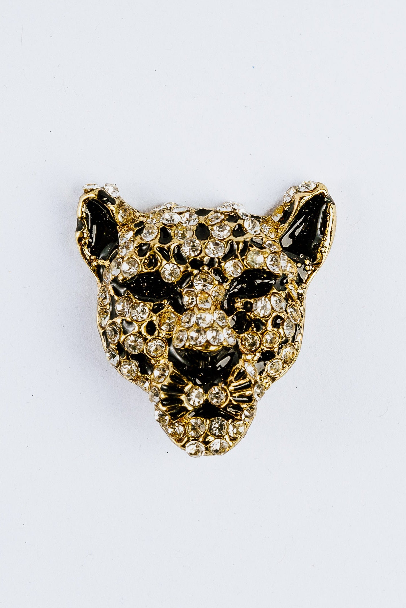 Gold and black jaguar head charm on a white background