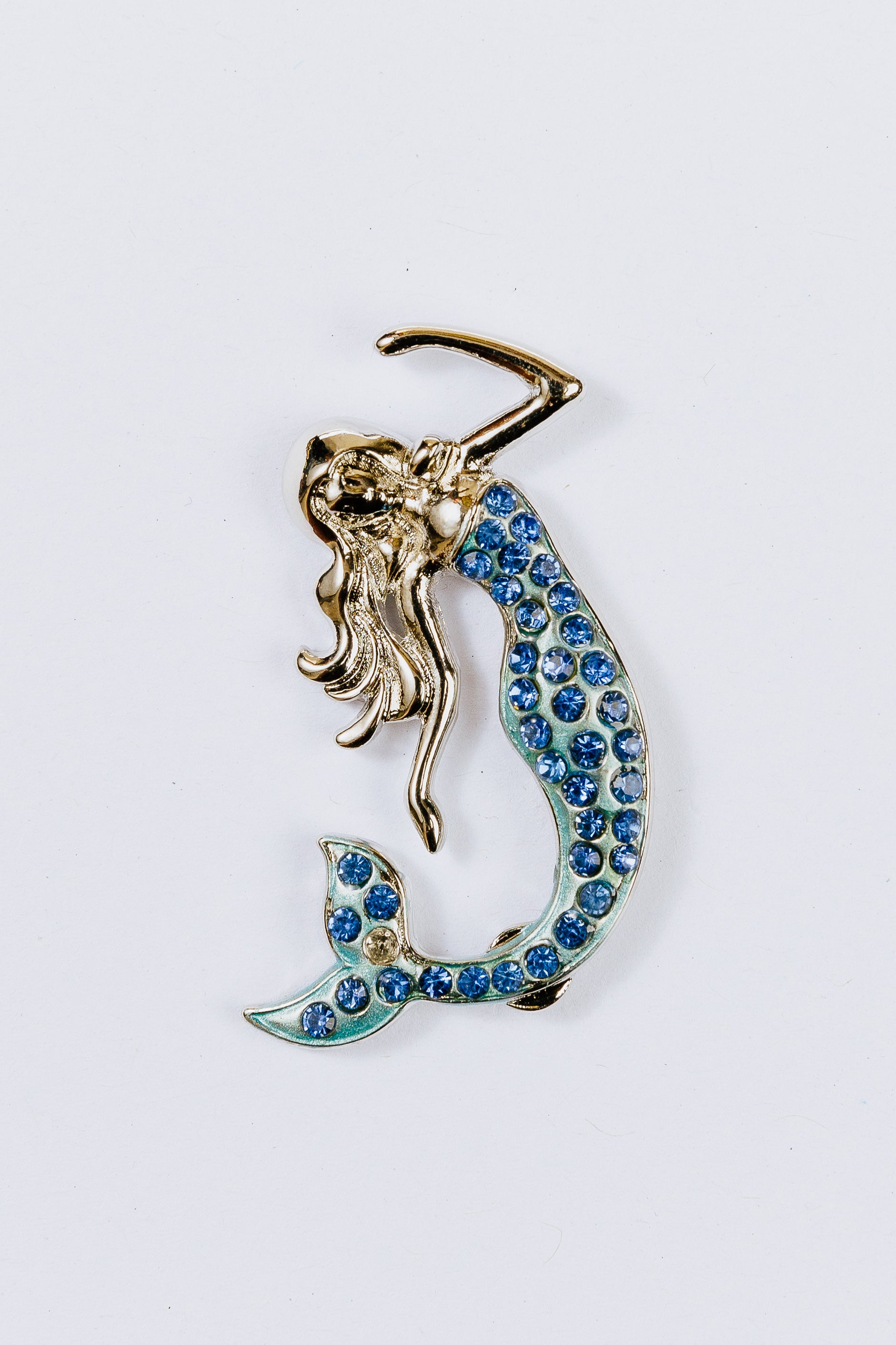 Mermaid charm with blue gemstones on a white background