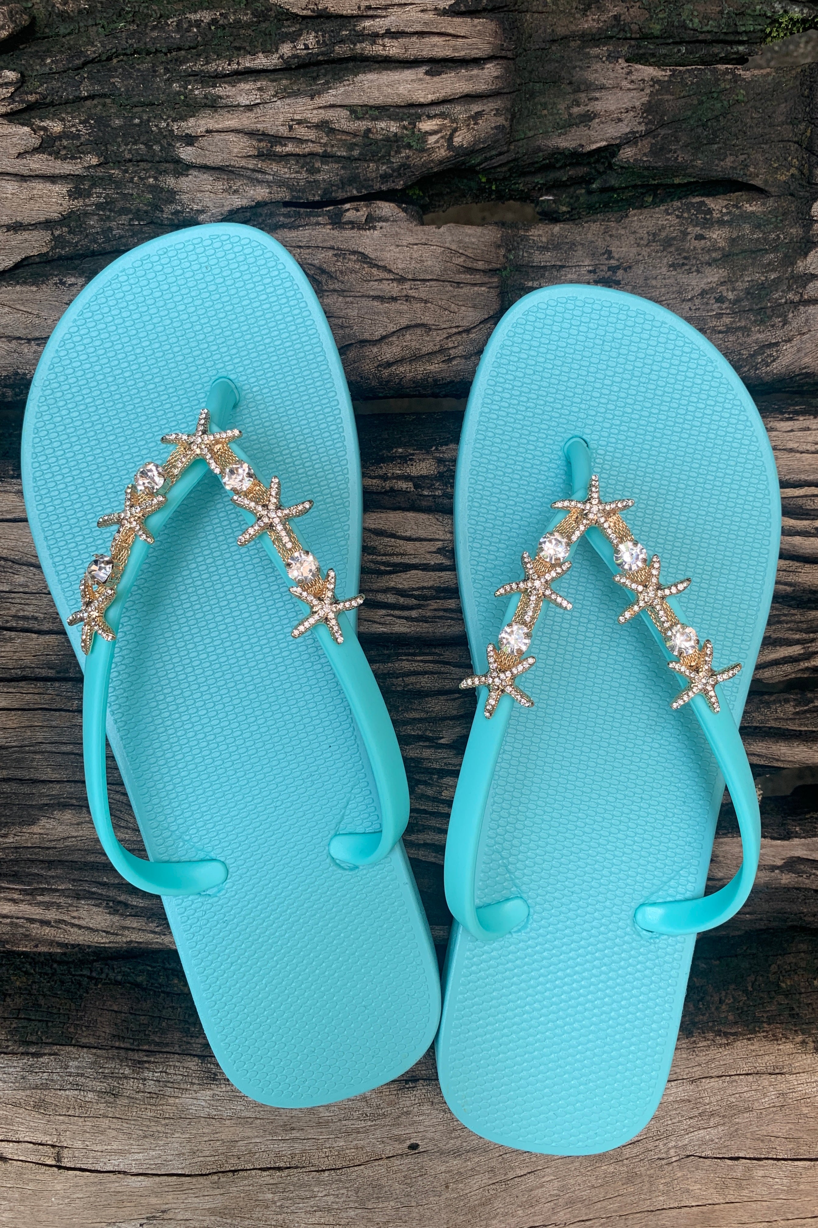 a pair of aqua flip-flops with a silver twin starfish arch charm