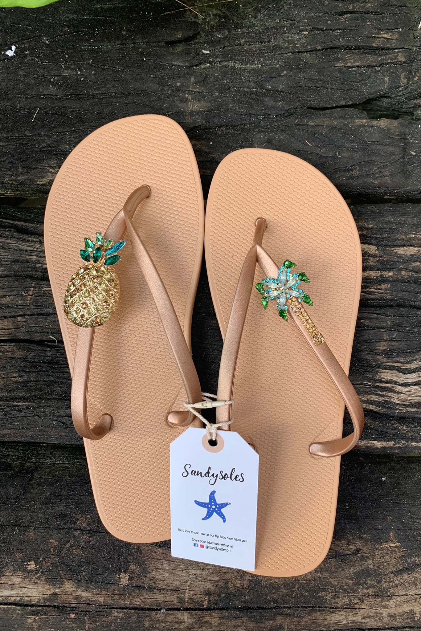 a pair of nude flipflops with decorative charms