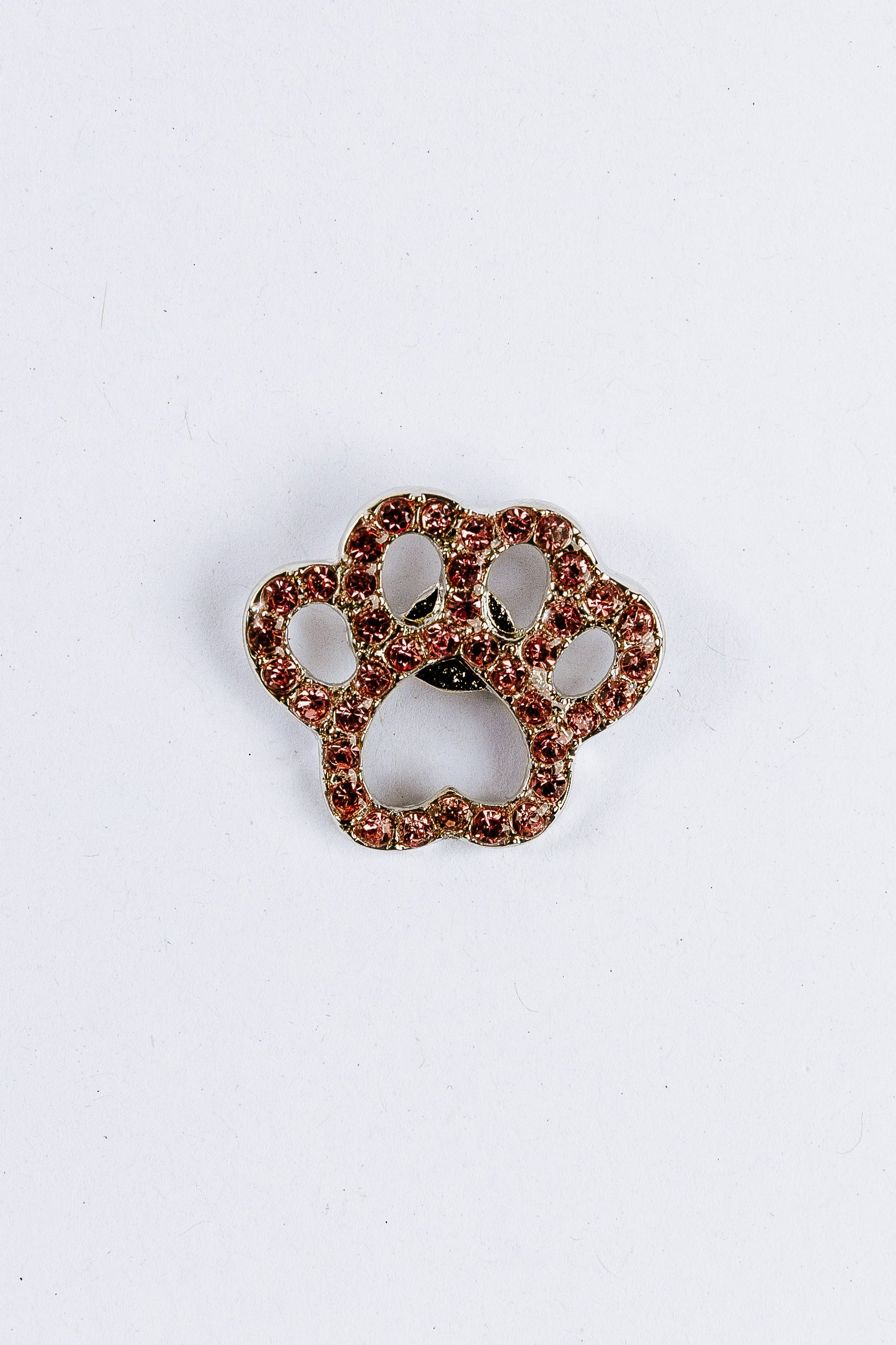 Paw print charm with gemstones on a white background