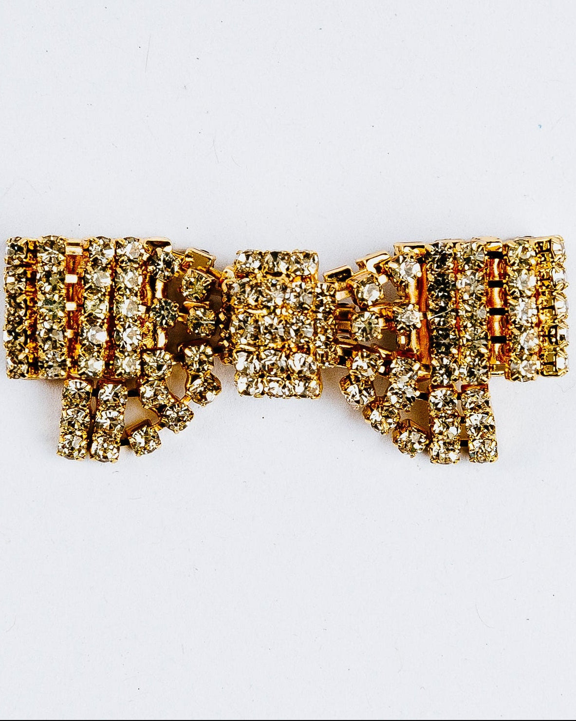 Gold bow-shaped brooch with rhinestones