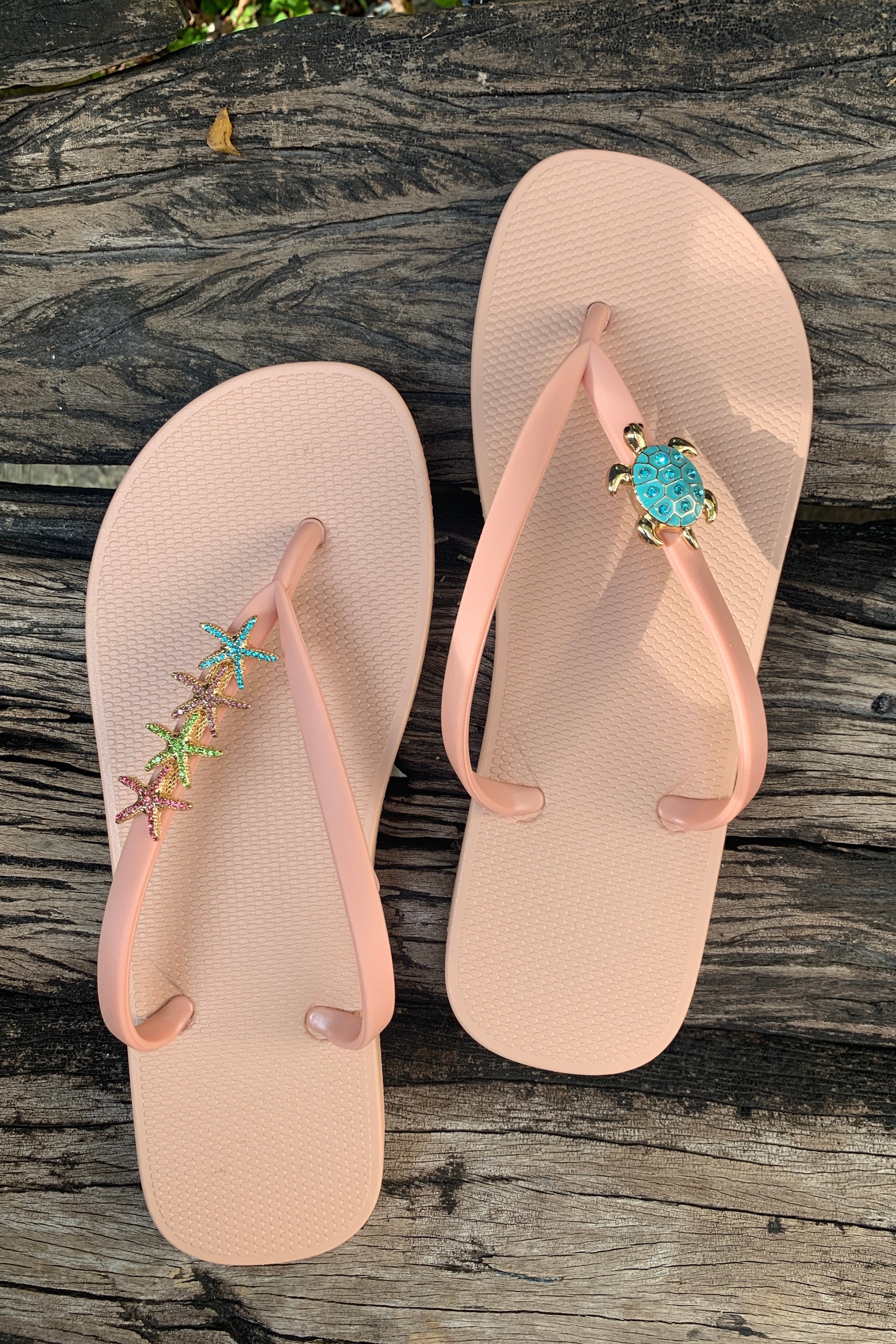 a pair of white flipflops with turtle and starfishes decorative charms