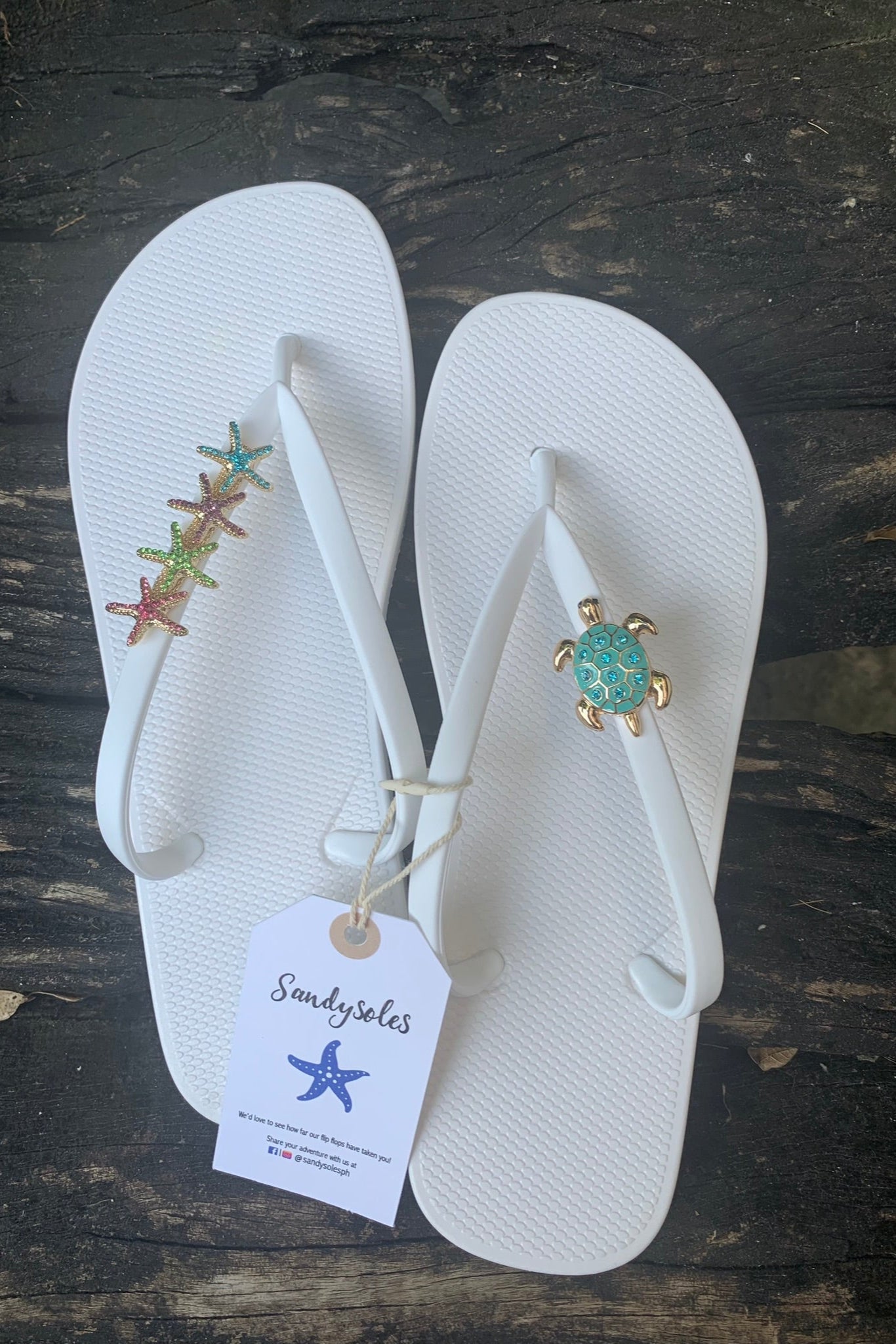 a pair of white flipflops with turtle and starfishes decorative charms