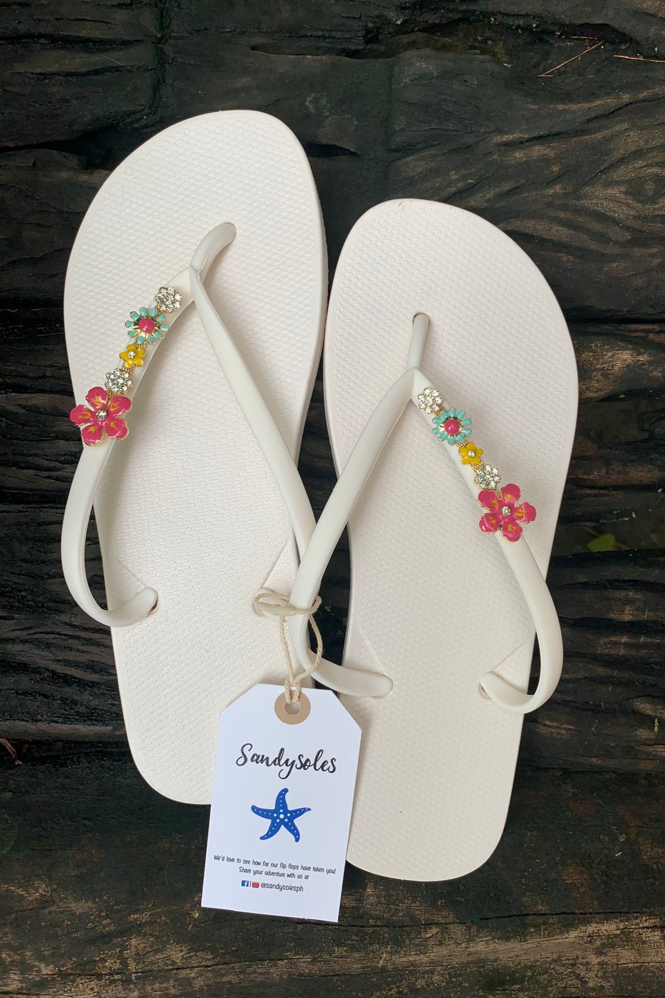 White flip-flops with decorative pink floral charms