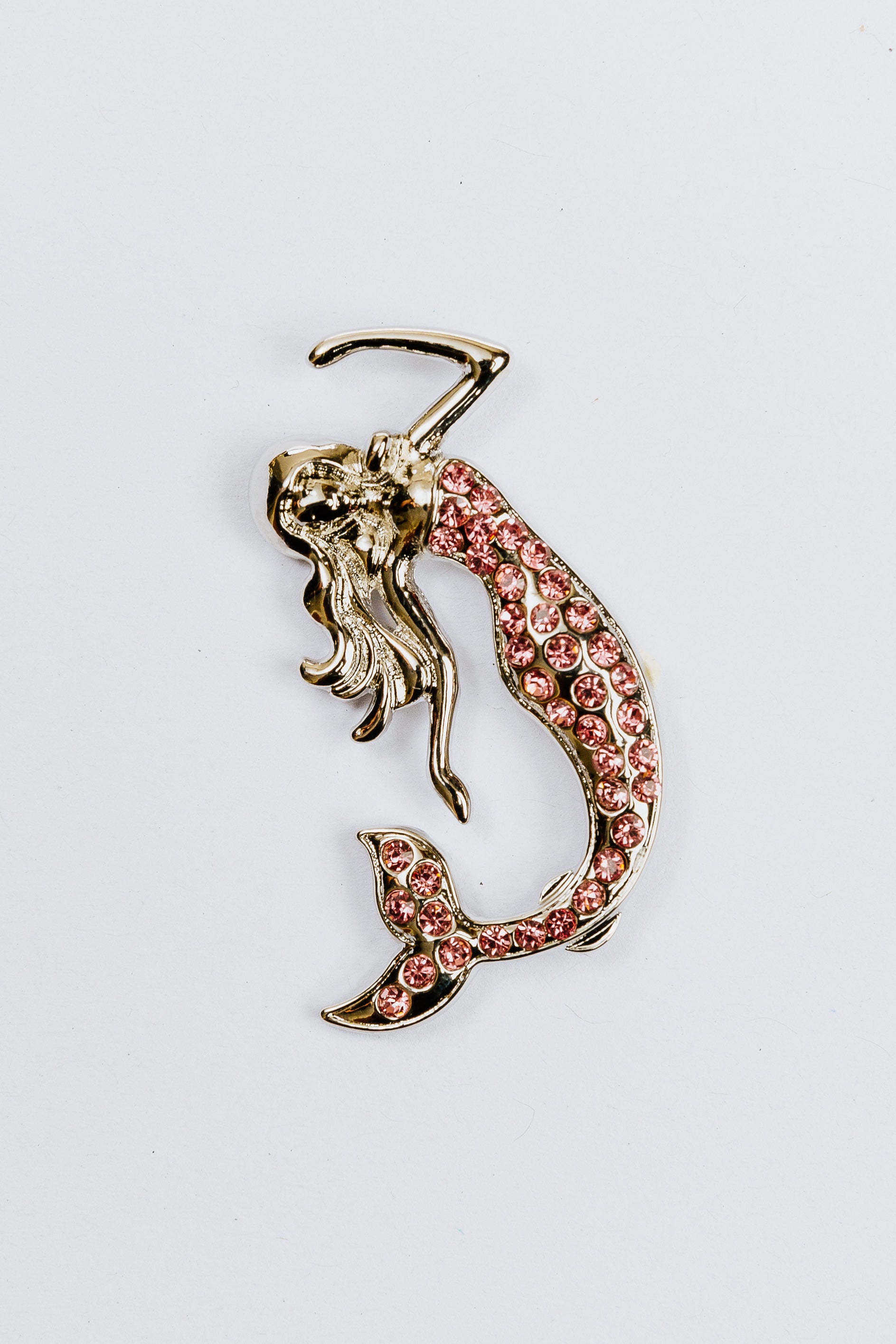 Mermaid charm with pink gemstones on a white background