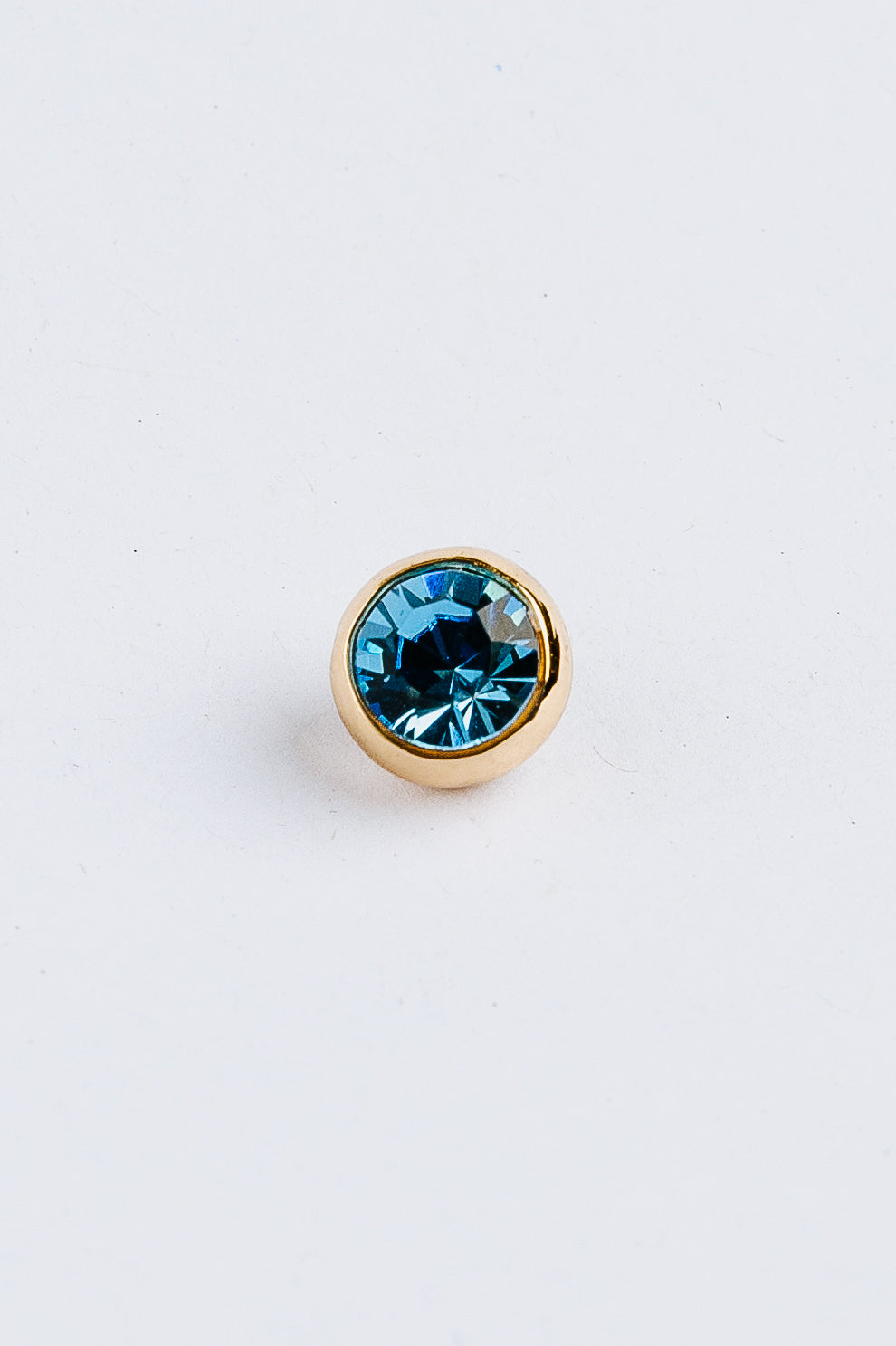 Blue gemstone charm on a white background