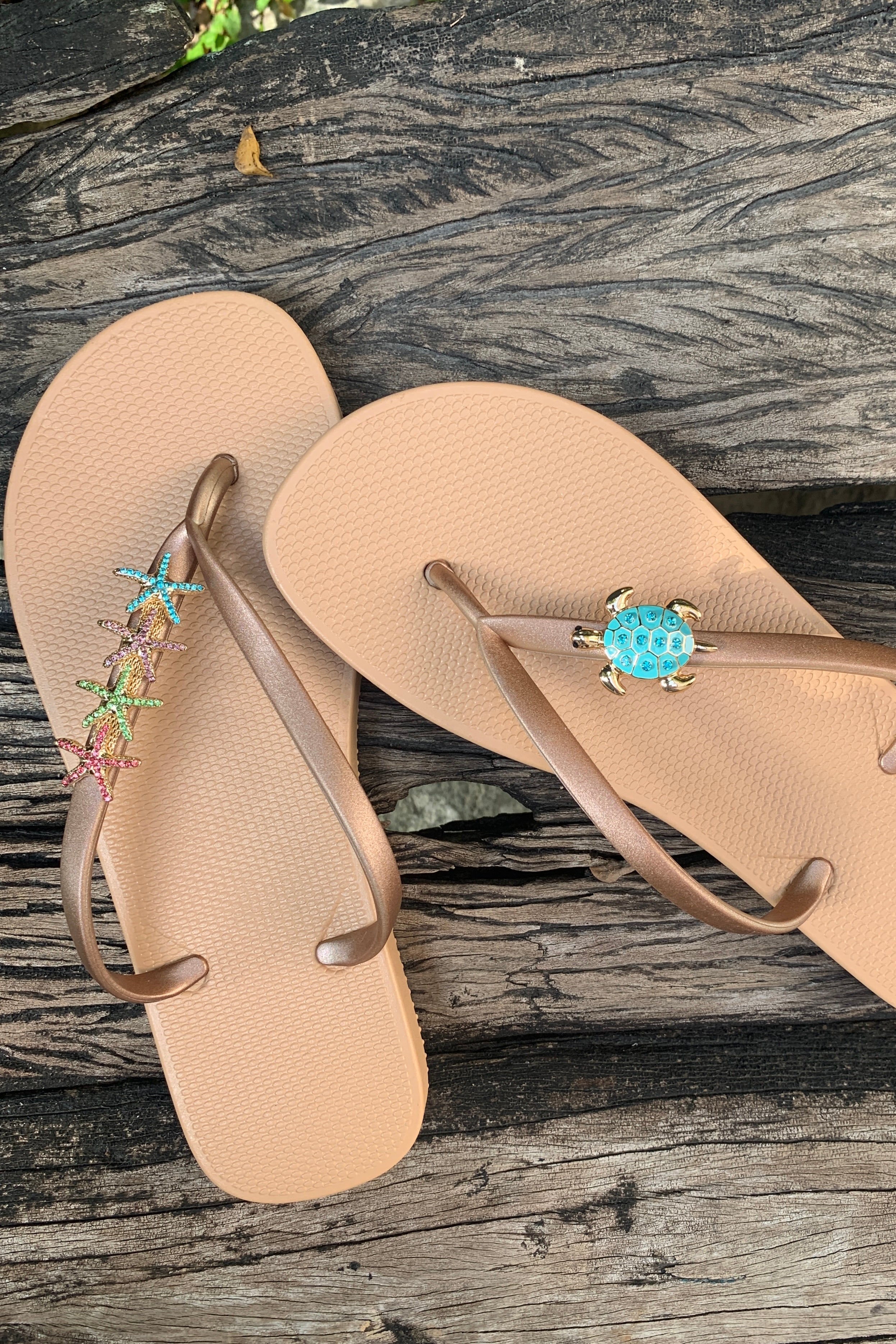 a pair of white flipflops with turtle and starfishes decorative charms
