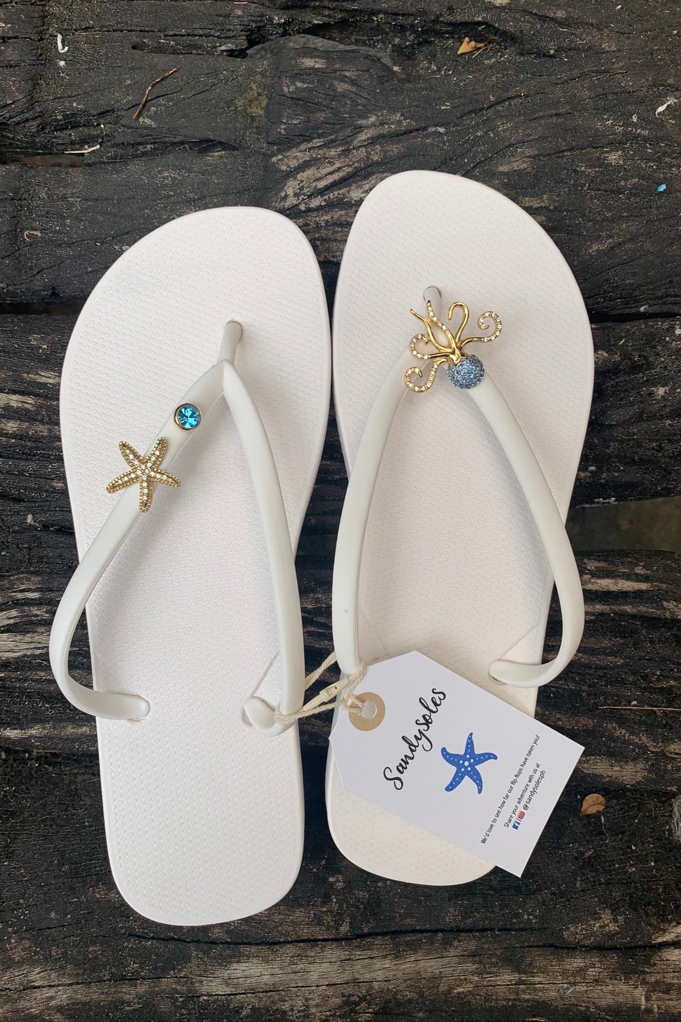 White flip-flops with octopus, starfish and blue gem charms on straps