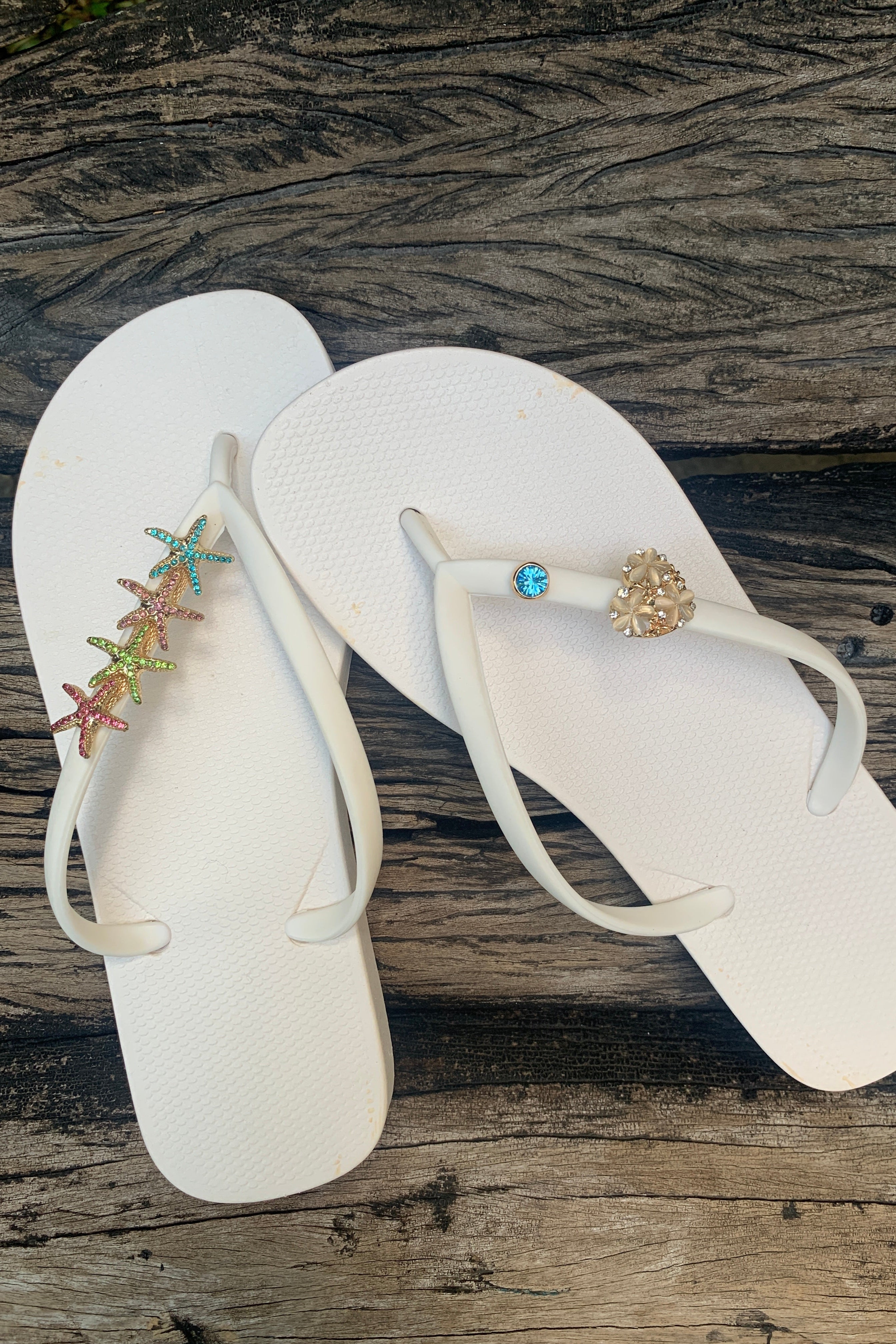 Pair of white flip-flops with decorative starfish and gemstone charms