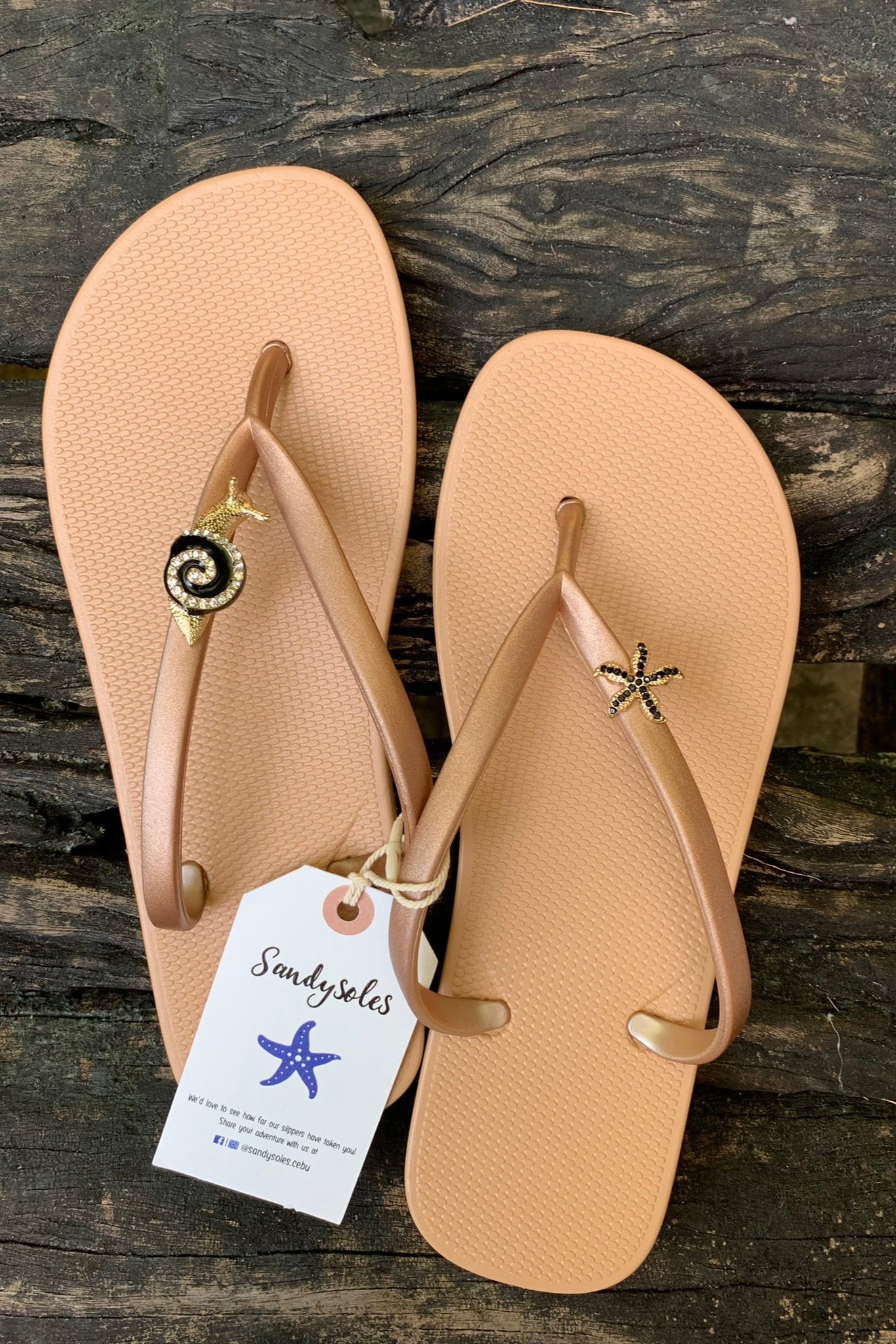 Pair of beige sandals with decorative charms on straps