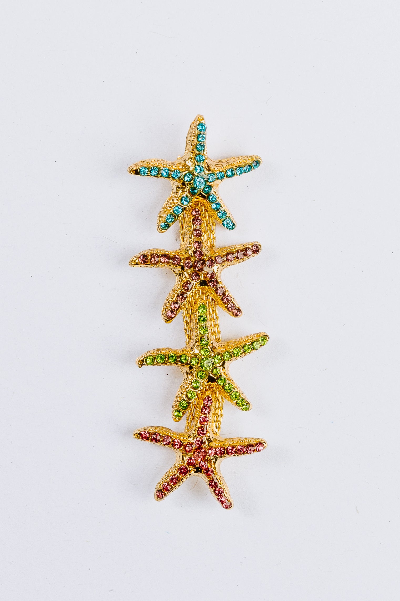 Starfish-shaped charm with colorful gemstones on a white background